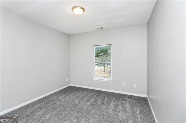 empty room featuring dark colored carpet