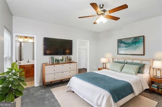 carpeted bedroom with ceiling fan, connected bathroom, and sink