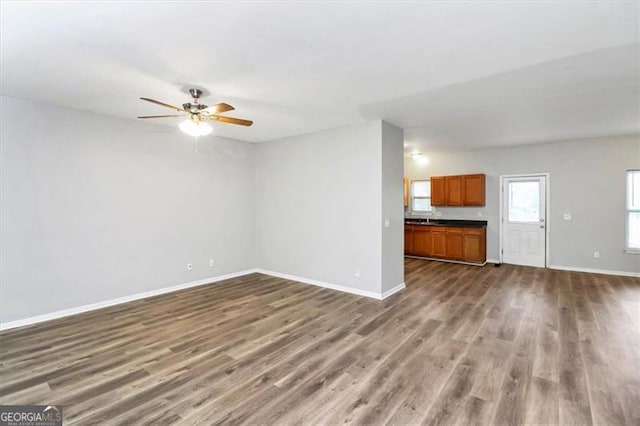 unfurnished living room with hardwood / wood-style floors and ceiling fan