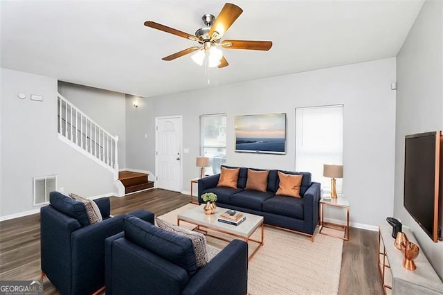 living room featuring ceiling fan and dark hardwood / wood-style floors