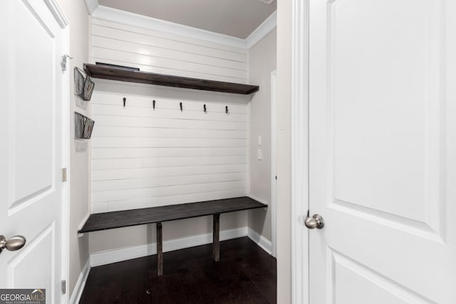 mudroom featuring dark hardwood / wood-style flooring, wooden walls, and ornamental molding