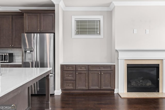 kitchen with dark brown cabinetry, stainless steel appliances, and dark hardwood / wood-style floors