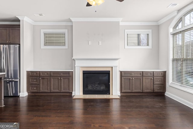 unfurnished living room featuring ornamental molding, plenty of natural light, ceiling fan, and dark hardwood / wood-style flooring