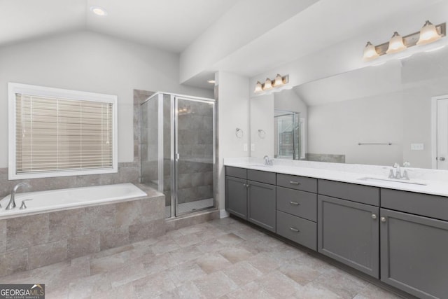 bathroom featuring vanity, lofted ceiling, and separate shower and tub