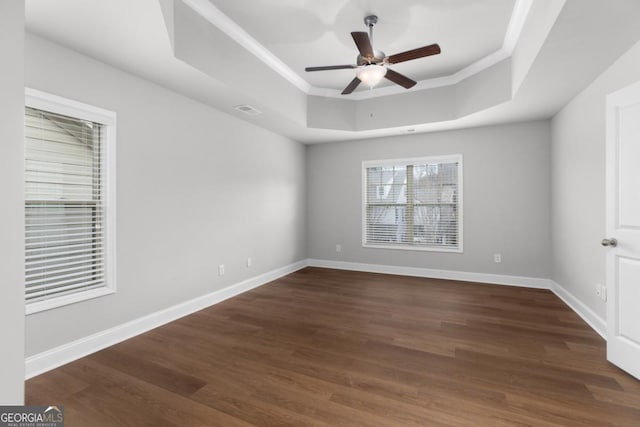 unfurnished room featuring ceiling fan, crown molding, dark hardwood / wood-style flooring, and a tray ceiling