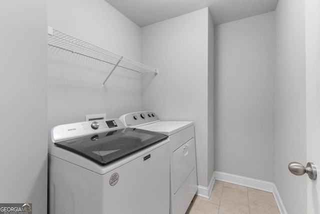 laundry room with light tile patterned floors and washer and clothes dryer