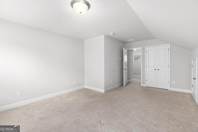 bonus room featuring light carpet and vaulted ceiling