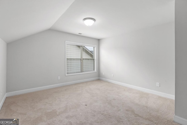 bonus room with light colored carpet and vaulted ceiling