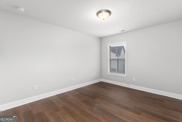 unfurnished room with dark wood-type flooring