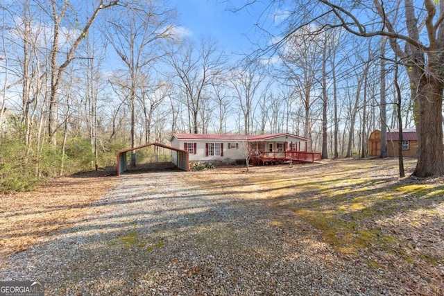 ranch-style house featuring a carport and a deck