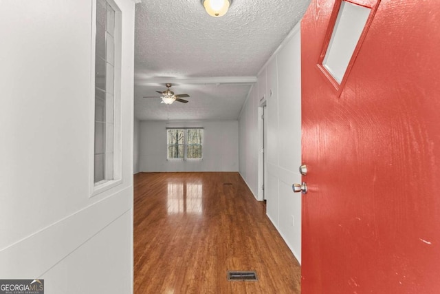 hallway with wood-type flooring and a textured ceiling