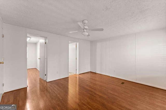 spare room featuring hardwood / wood-style flooring, ceiling fan, and a textured ceiling