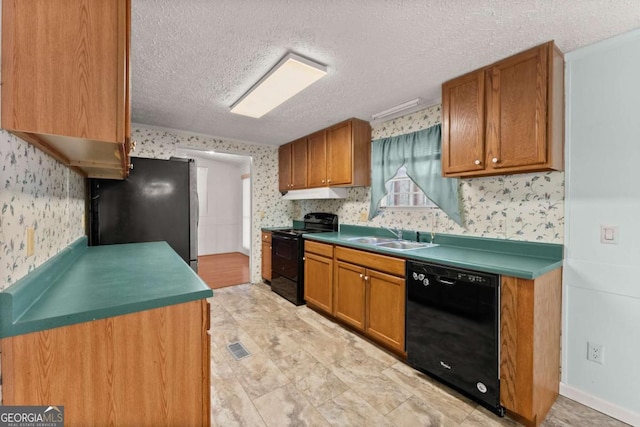 kitchen featuring sink, black appliances, and a textured ceiling