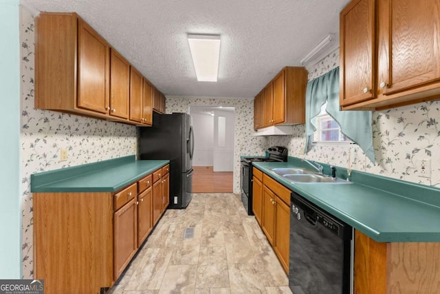 kitchen featuring sink, black appliances, and a textured ceiling