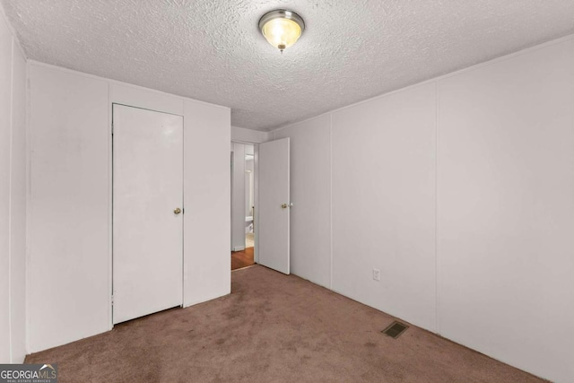 unfurnished bedroom featuring carpet flooring and a textured ceiling