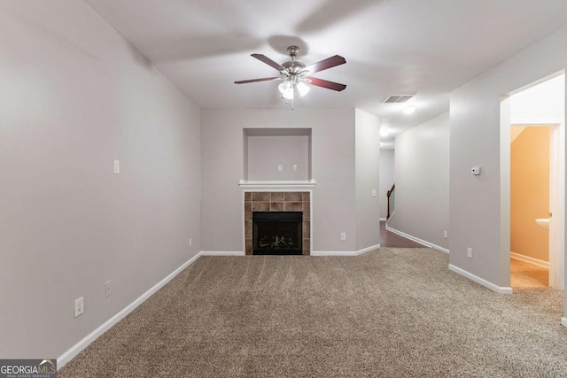 unfurnished living room featuring ceiling fan, carpet flooring, and a fireplace