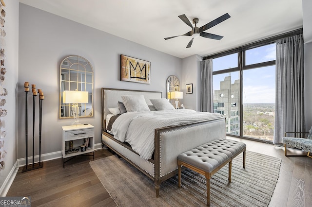 bedroom featuring dark wood-type flooring, ceiling fan, expansive windows, and access to outside