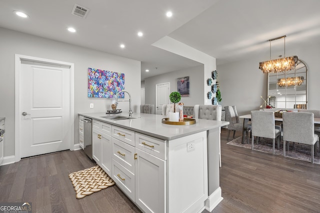 kitchen with sink, white cabinetry, dark hardwood / wood-style flooring, dishwasher, and a notable chandelier