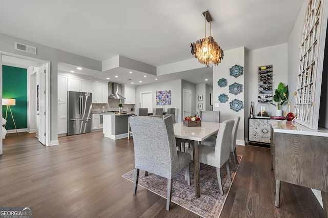 dining area featuring dark wood-type flooring and a chandelier