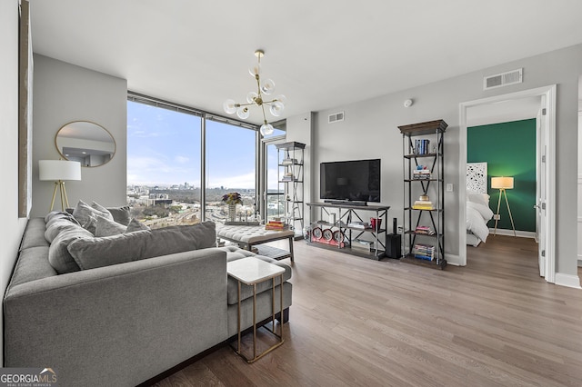 living room featuring hardwood / wood-style flooring, floor to ceiling windows, and a notable chandelier