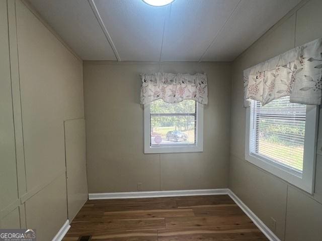 unfurnished dining area featuring dark wood-type flooring and lofted ceiling