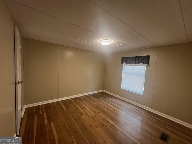 spare room with dark hardwood / wood-style flooring