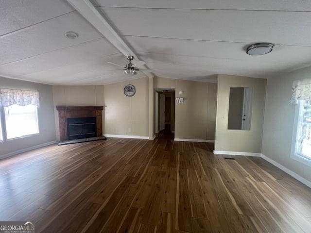 unfurnished living room with ceiling fan, plenty of natural light, and dark hardwood / wood-style flooring