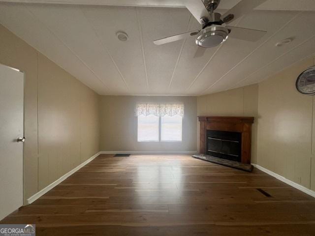 unfurnished living room featuring dark wood-type flooring and ceiling fan