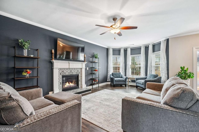 living room with dark hardwood / wood-style floors, ceiling fan, ornamental molding, and a fireplace