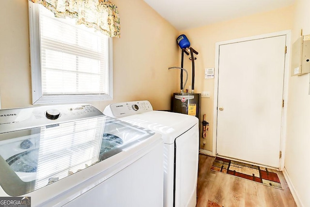 washroom with water heater, washing machine and dryer, and light hardwood / wood-style flooring