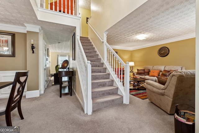 stairway featuring ornamental molding, carpet flooring, and a textured ceiling