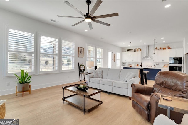 living room with ceiling fan and light hardwood / wood-style floors