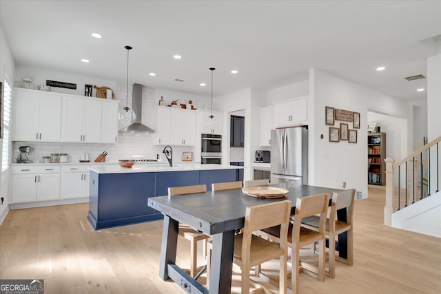 dining room featuring sink and light hardwood / wood-style flooring