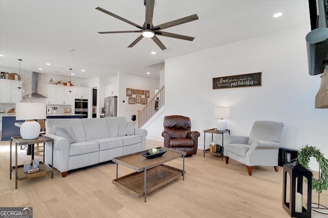 living room with recessed lighting, ceiling fan, stairway, and light wood finished floors