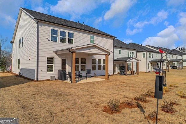 rear view of property with a lawn and a patio area