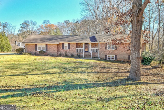 ranch-style home with covered porch, brick siding, and a front yard