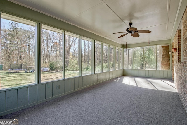 unfurnished sunroom featuring ceiling fan and a wealth of natural light