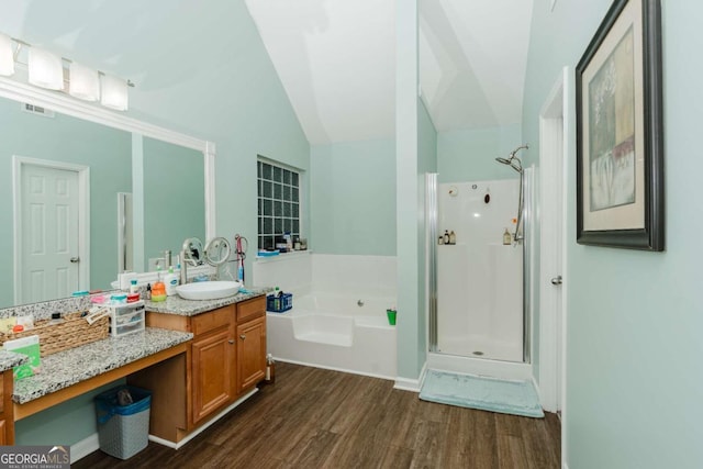 bathroom featuring independent shower and bath, vanity, lofted ceiling, and hardwood / wood-style flooring