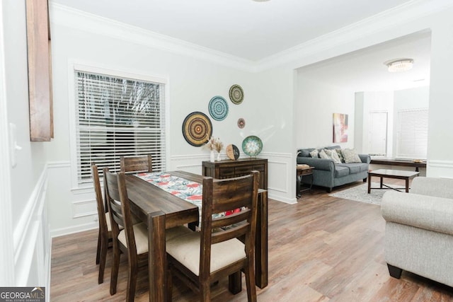 dining room featuring crown molding and light hardwood / wood-style flooring