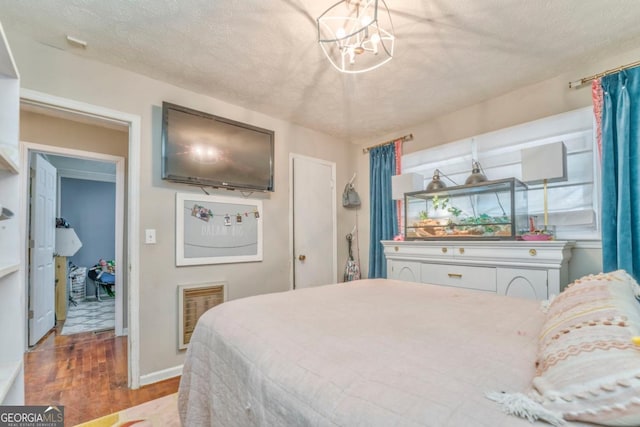 bedroom with wood-type flooring, a chandelier, and a textured ceiling