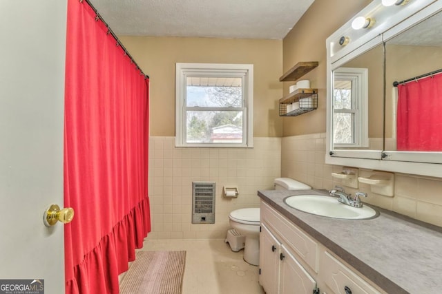 bathroom with toilet, heating unit, tile walls, a textured ceiling, and vanity