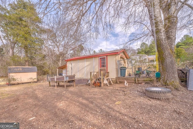 rear view of house featuring a shed