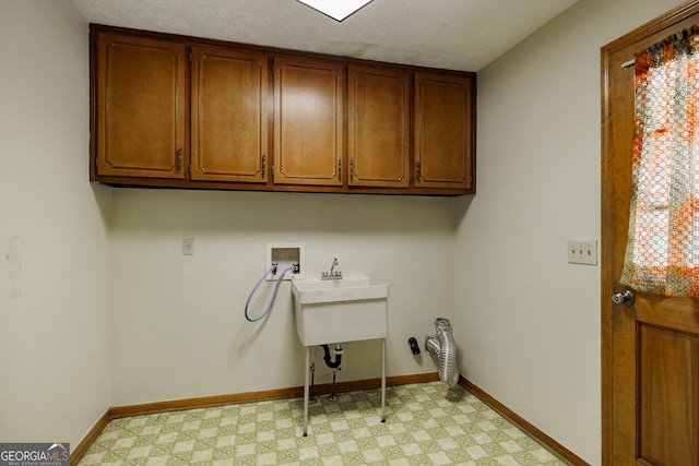 washroom featuring washer hookup, a wealth of natural light, cabinets, and a textured ceiling