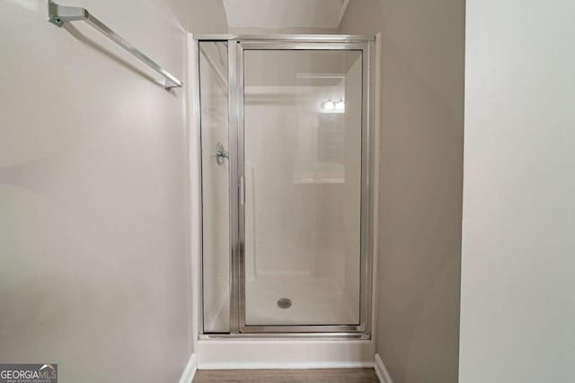 bathroom featuring a shower with door