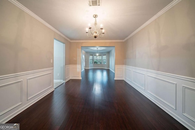 unfurnished dining area with ornamental molding, dark hardwood / wood-style flooring, and a chandelier