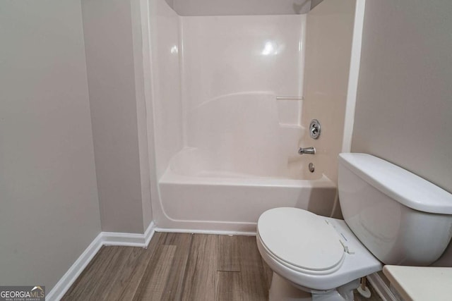 bathroom featuring hardwood / wood-style floors, bathing tub / shower combination, and toilet