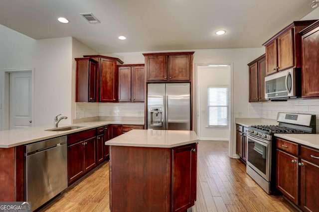 kitchen featuring appliances with stainless steel finishes, a center island, and light hardwood / wood-style floors