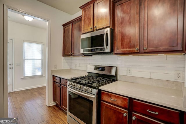 kitchen featuring tasteful backsplash, hardwood / wood-style flooring, and appliances with stainless steel finishes