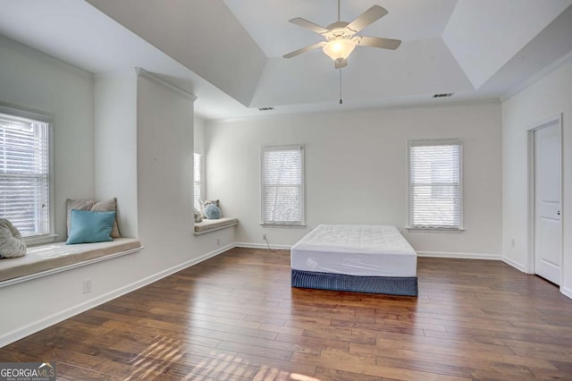 unfurnished bedroom featuring dark hardwood / wood-style floors, ceiling fan, and a tray ceiling