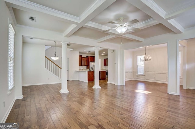 unfurnished living room with beamed ceiling, coffered ceiling, decorative columns, and hardwood / wood-style floors